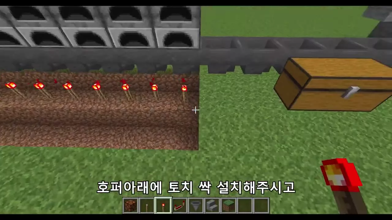 호퍼 아래에 레드스톤 토치를 줄줄이 설치하는 모습
